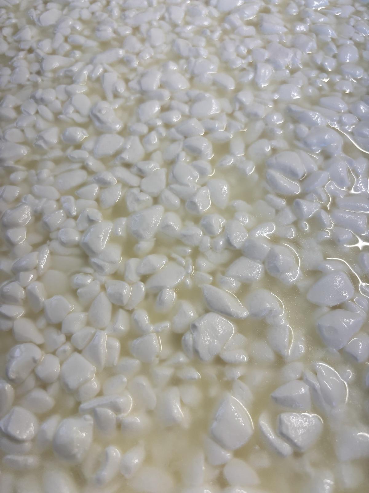 Grains de caillé en surface d'une cuve de fabrication